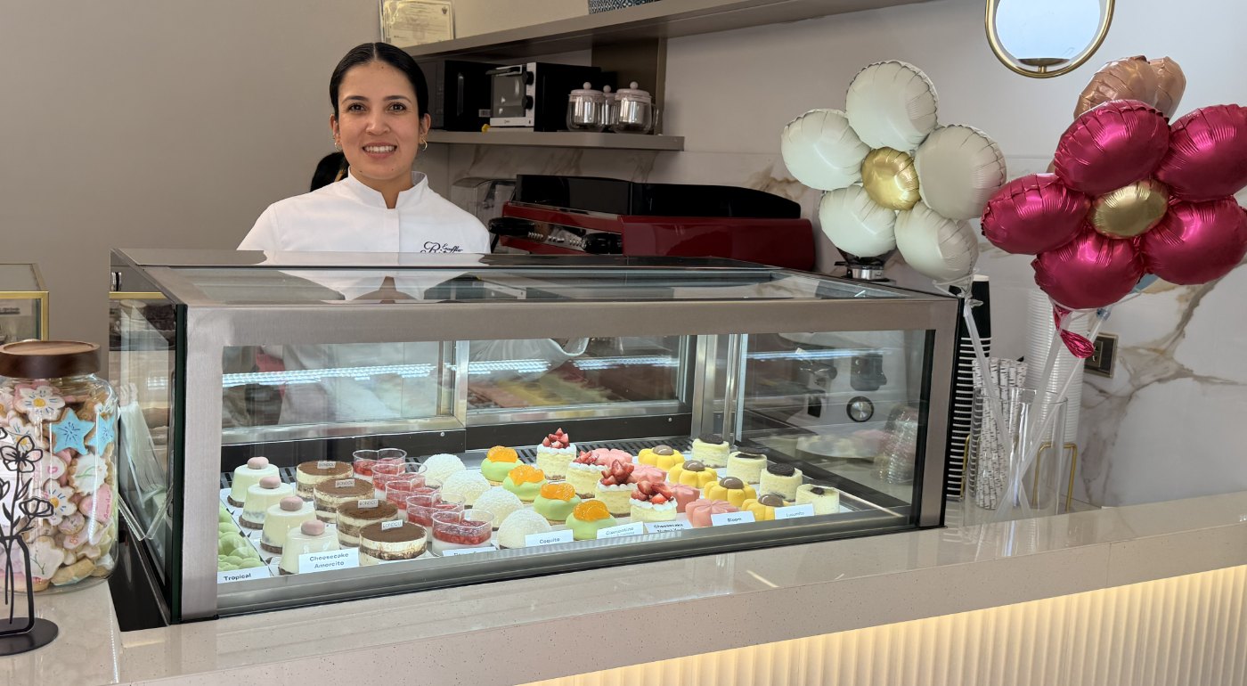La vitrina de Bondou en Umacollo, llena de postres, con Ana Paula detrás